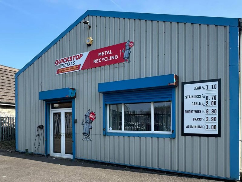 QuickStop Metals Stockport scrap yard, Omega Works, Bredbury — exterior view with mascot signage and price board